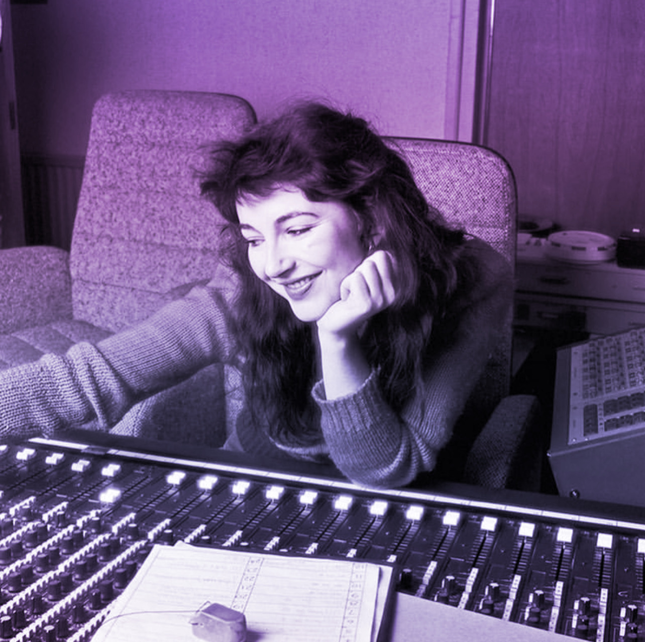 Kate Bush sitting at the mixing board in the studio